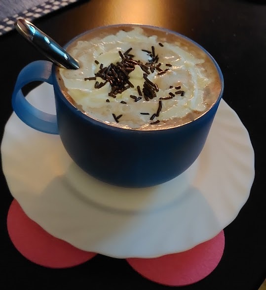 Eine Tasse Kakao mit Schlagsahne und Schokoladenstreusel